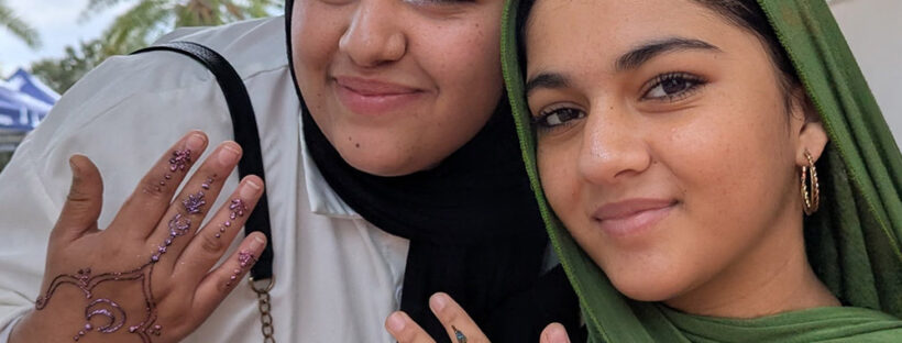 Two Muslim students showing off henna designs