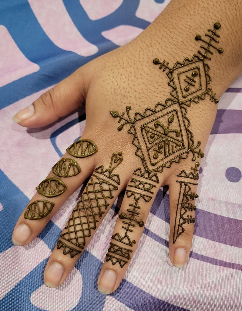 Traditional Fessi Moroccan henna design on the top of a hand.