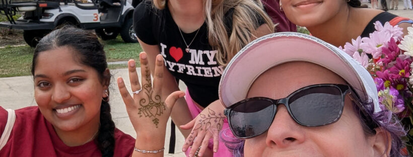 Jody with 3 students getting henna at a campus Valentine event.