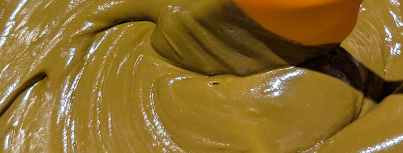 Freshy mixed ORa henna paste in a bowl with a spatula.