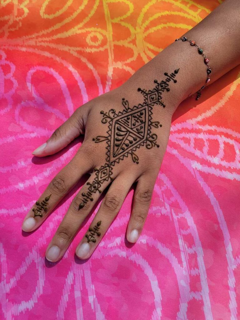 A Fessi Moroccan henna design on the top of a hand.