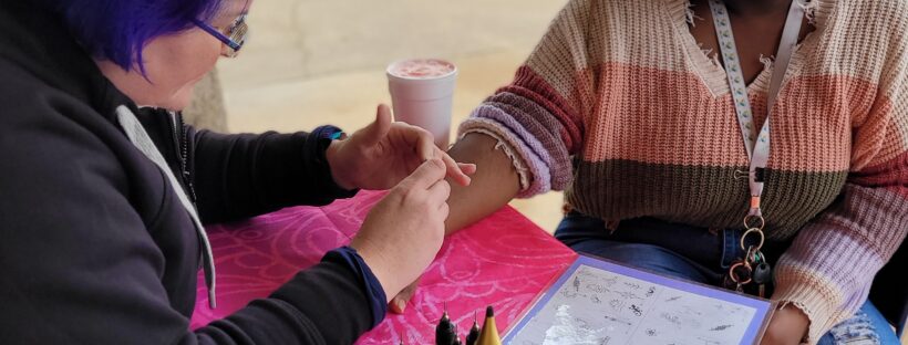 Henna artist doing henna on a student